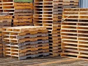 image shows stacked pallets depicting that we buy used wooden pallets
